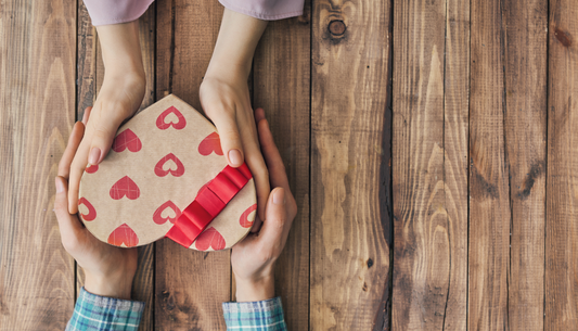 couple qui se tient les mains et un cadeau en forme de coeur