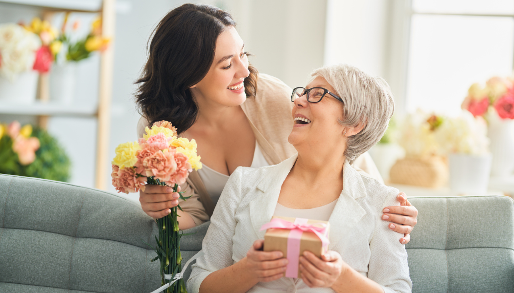femme qui offre un cadeau et des fleurs à sa mère