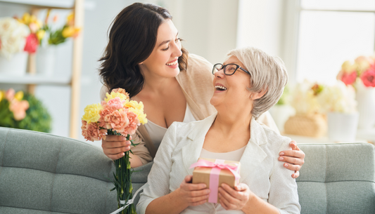 femme qui offre un cadeau et des fleurs à sa mère