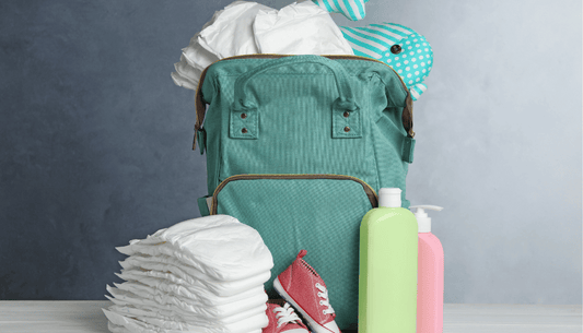 sac portant les affaires necessaires de bébé : couche, peluche, produits